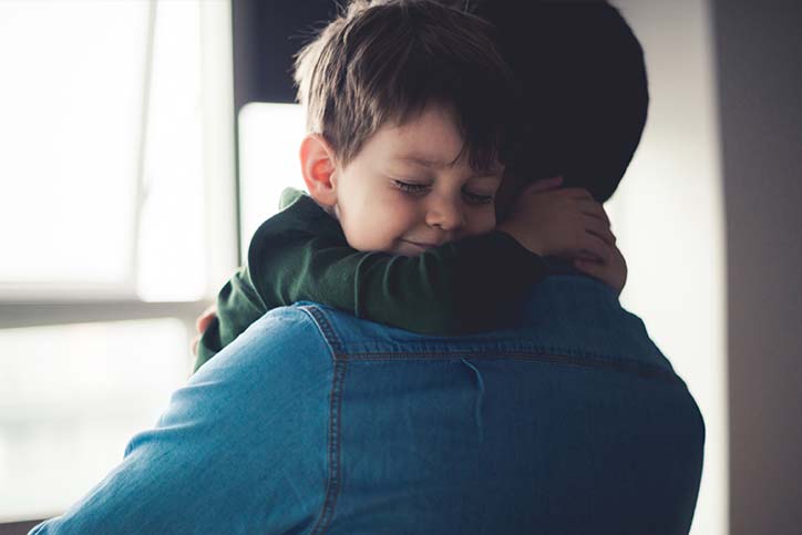 Child giving father a cuddle